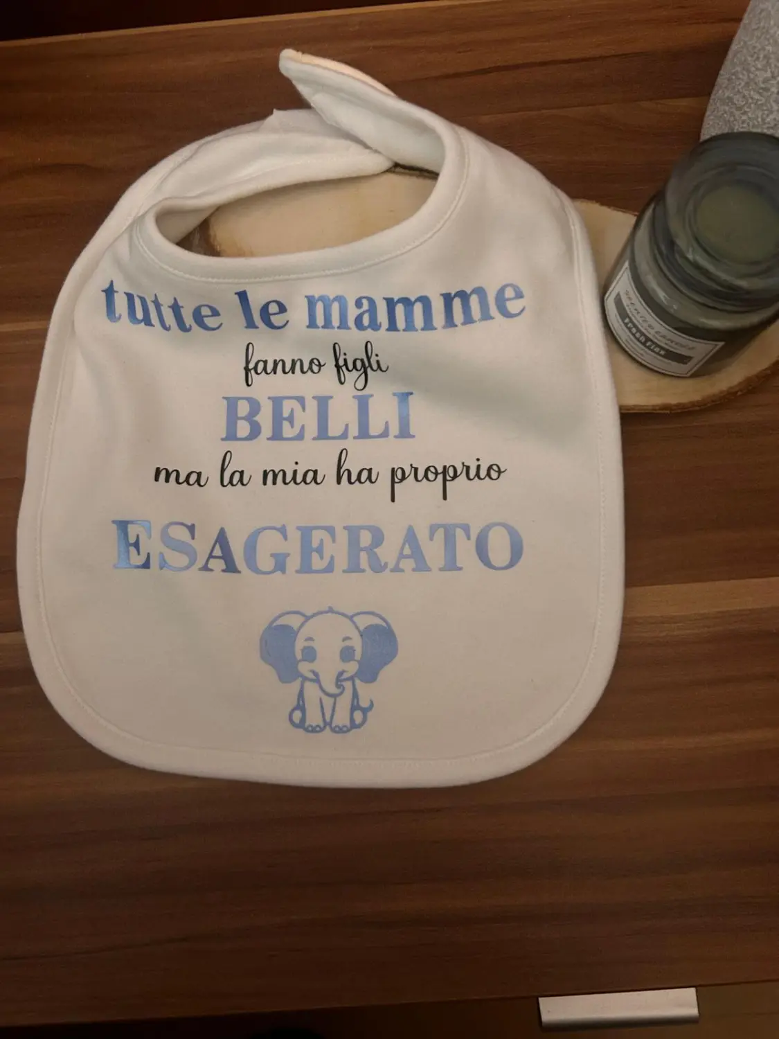 Ein personalisiertes Baby-Geschenkset mit Strampler, Mütze und Lätzchen. Alle Sets tragen den Namen „Xenia“ und ein verspieltes Elefantenmotiv. Dazu der italienische Spruch: „Tutte le mamme fanno figli BELLI ma la mia ha proprio ESAGERATO“ von Marikas Traumwelt.